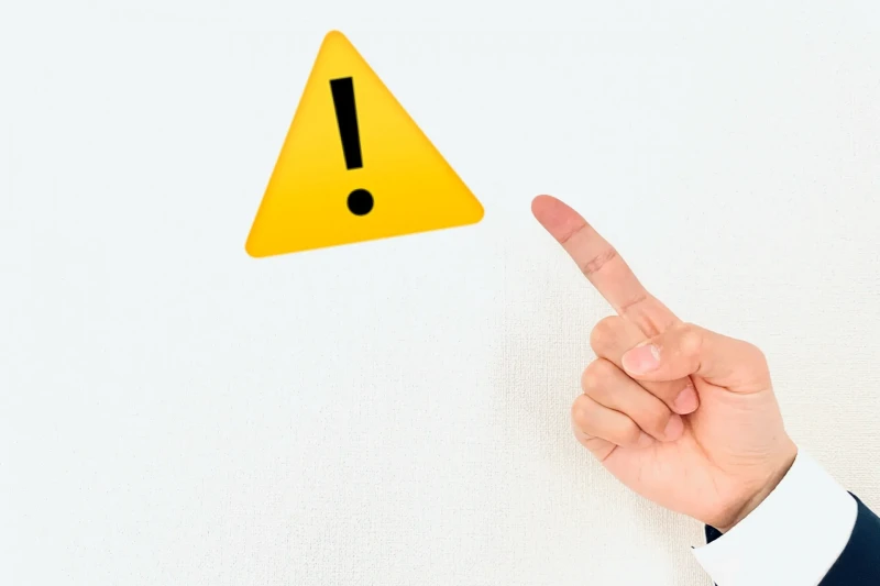 注意マークを指差しする画像