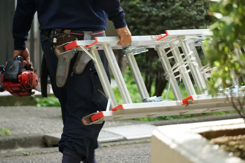 梯子をもって移動する職人の様子